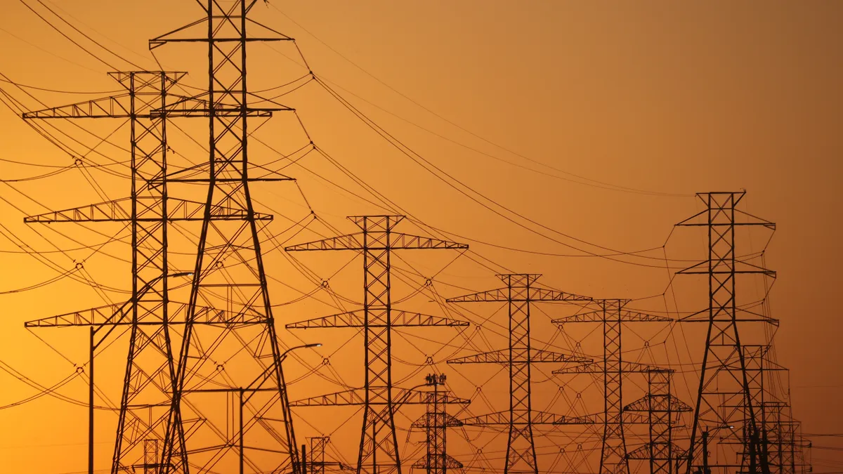 High voltage transmission lines are seen against an orange sky in Texas.