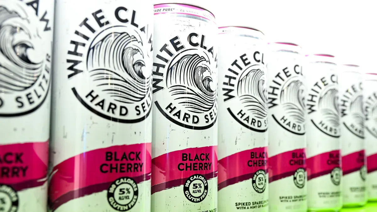 Cans of White Claw are displayed next to each other in a line.