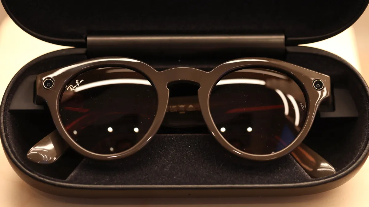 A pair of black Ray-Ban sunglasses sits in a black case on display.