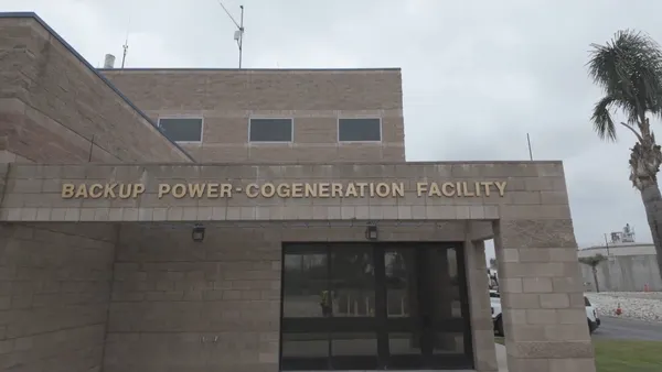 A cinderblock building with the name "Back Power Co-Generation Facility" on its front entrance.