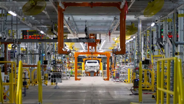 A vehicle body is lifted by a hoist at General Motors' factory Zero EV plant in Michigan in 2021.