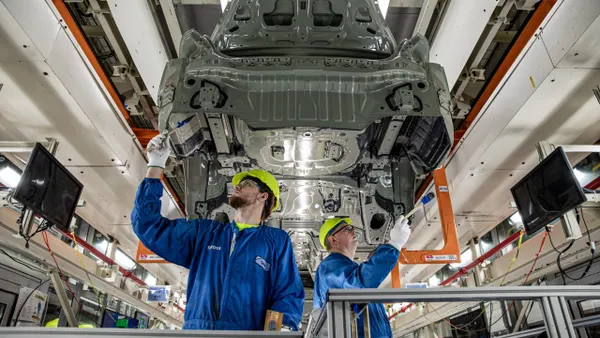 Two workers inspect a vehicle body on the assembly line at Toyota Motor Manufacturing Kentucky.