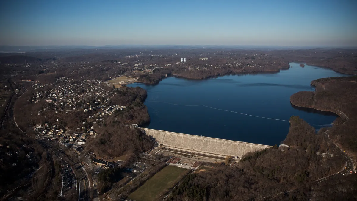 A aerial view of a large reservoir with trees along the shore.