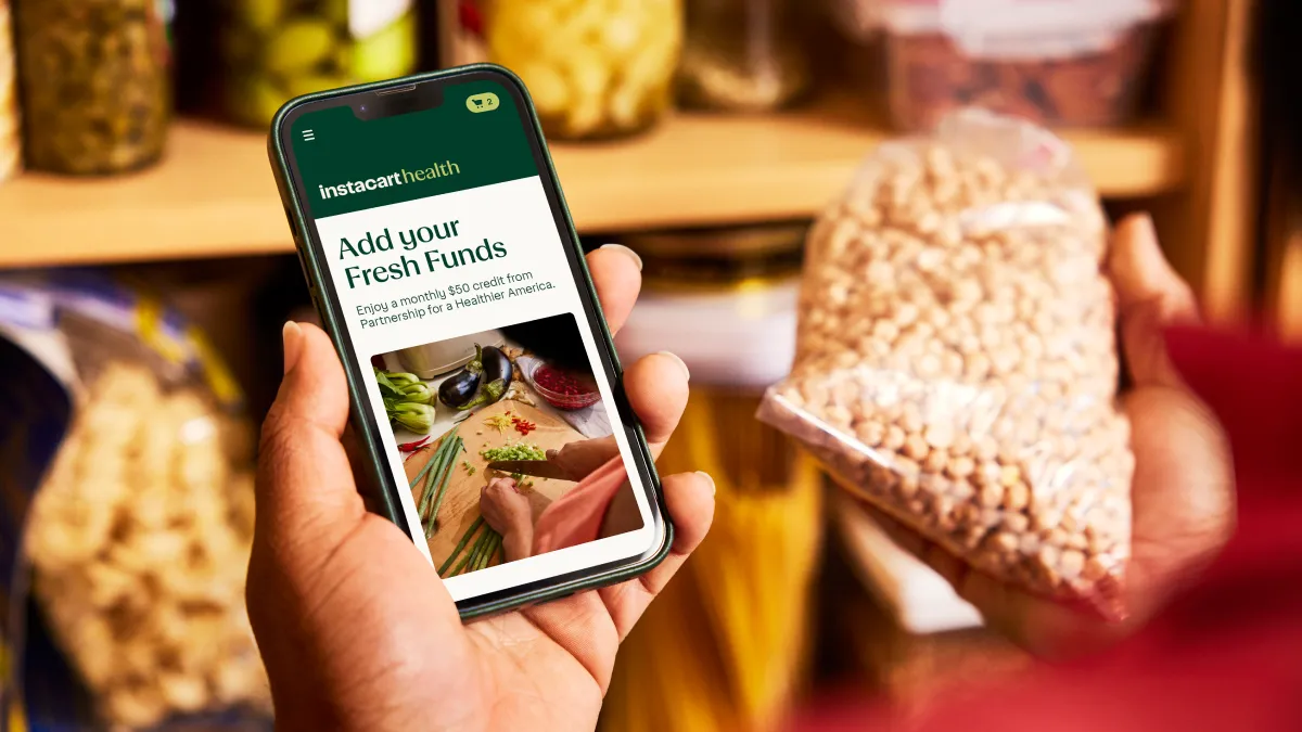 Close-up of a hand holding a phone with a screen that says "Add your Fresh Funds"