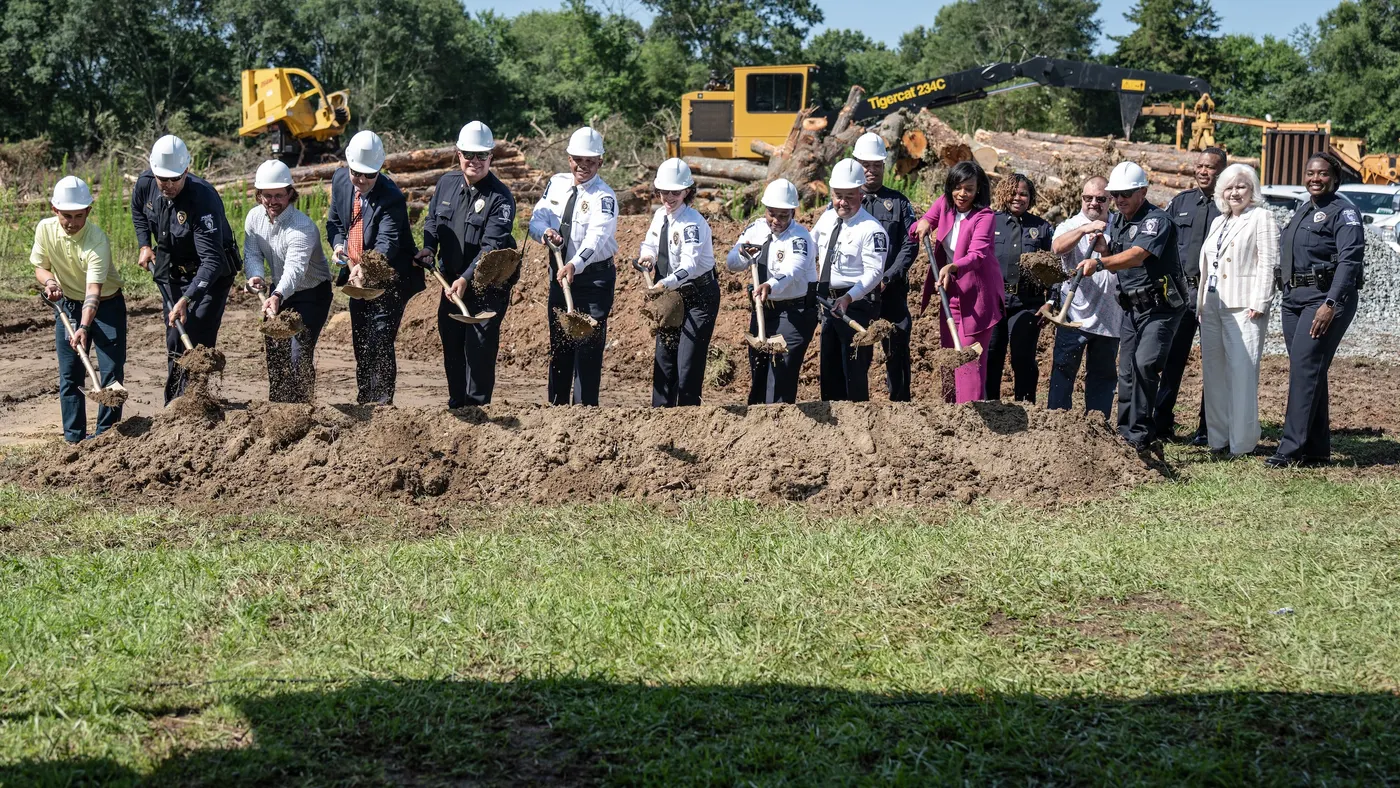 A line of people, including several police officers, with shovels