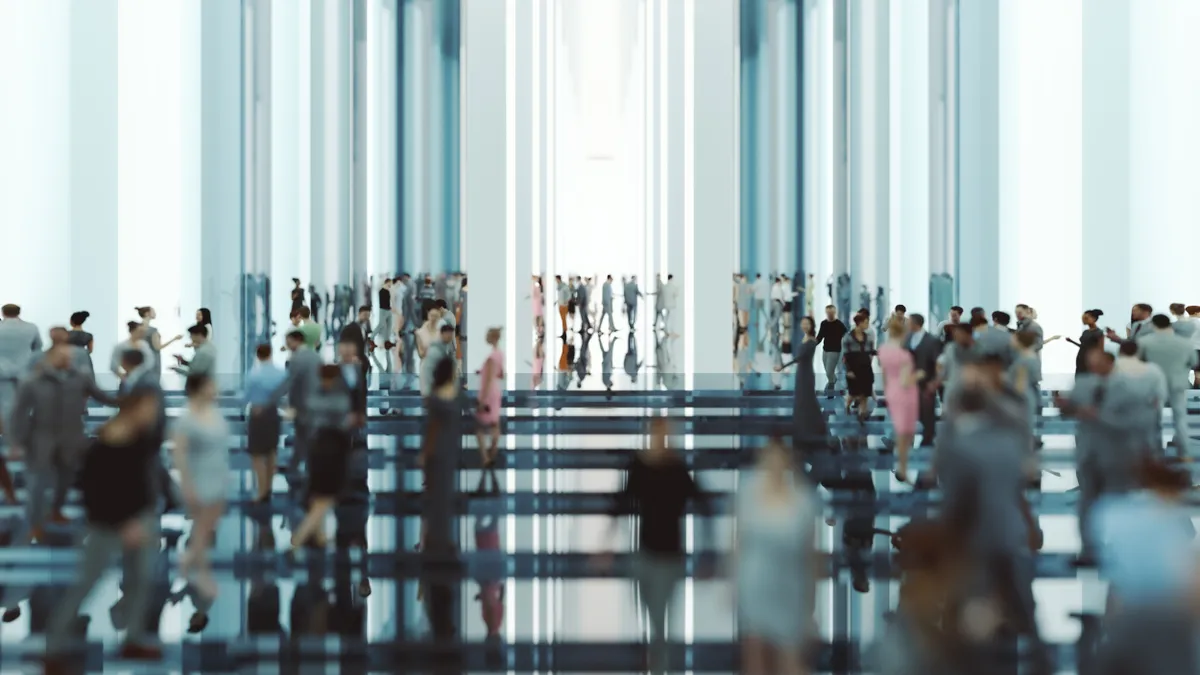 a picture of people walking through a modern glass lobby