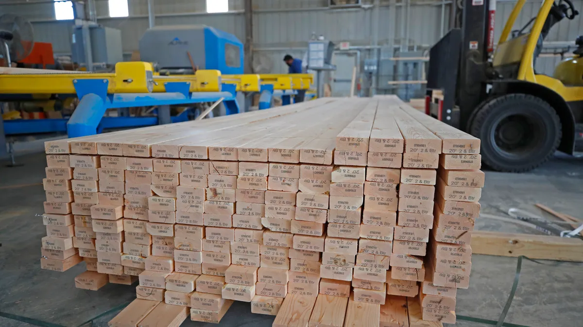 A stack of pieces of lumber moved by a forklift.