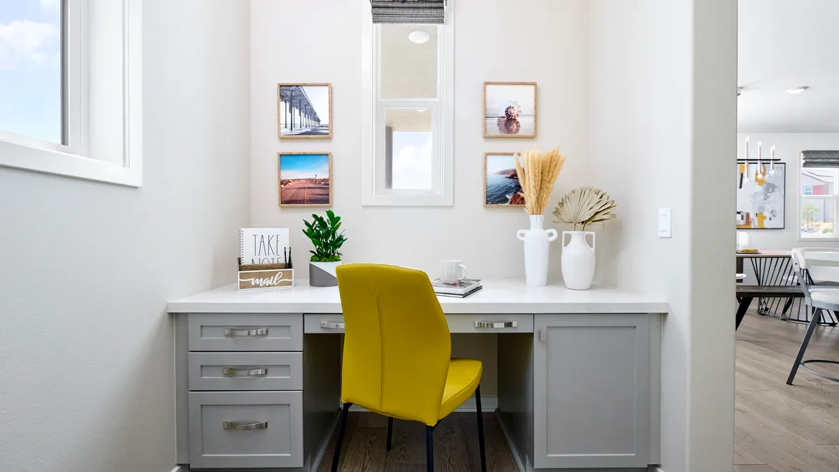 A desk and office chair in the corner of a home.