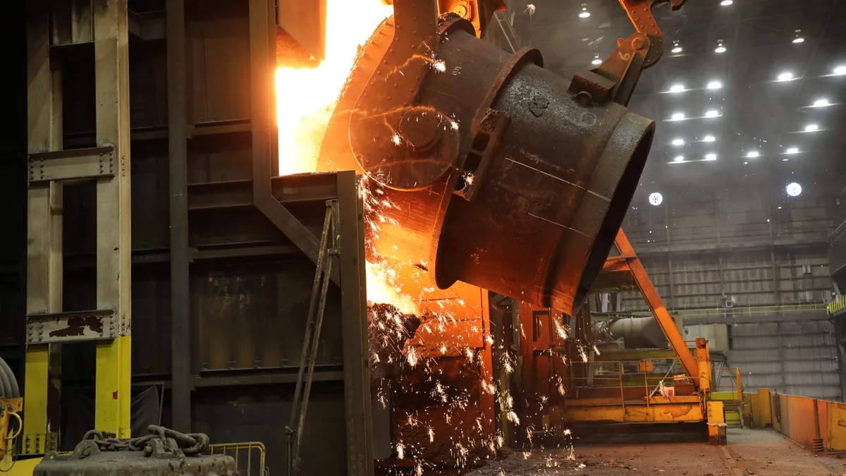 A ladle of holt molten iron is poured into a Basic Oxygen Process furnace where it will be transformed into liquid steel.