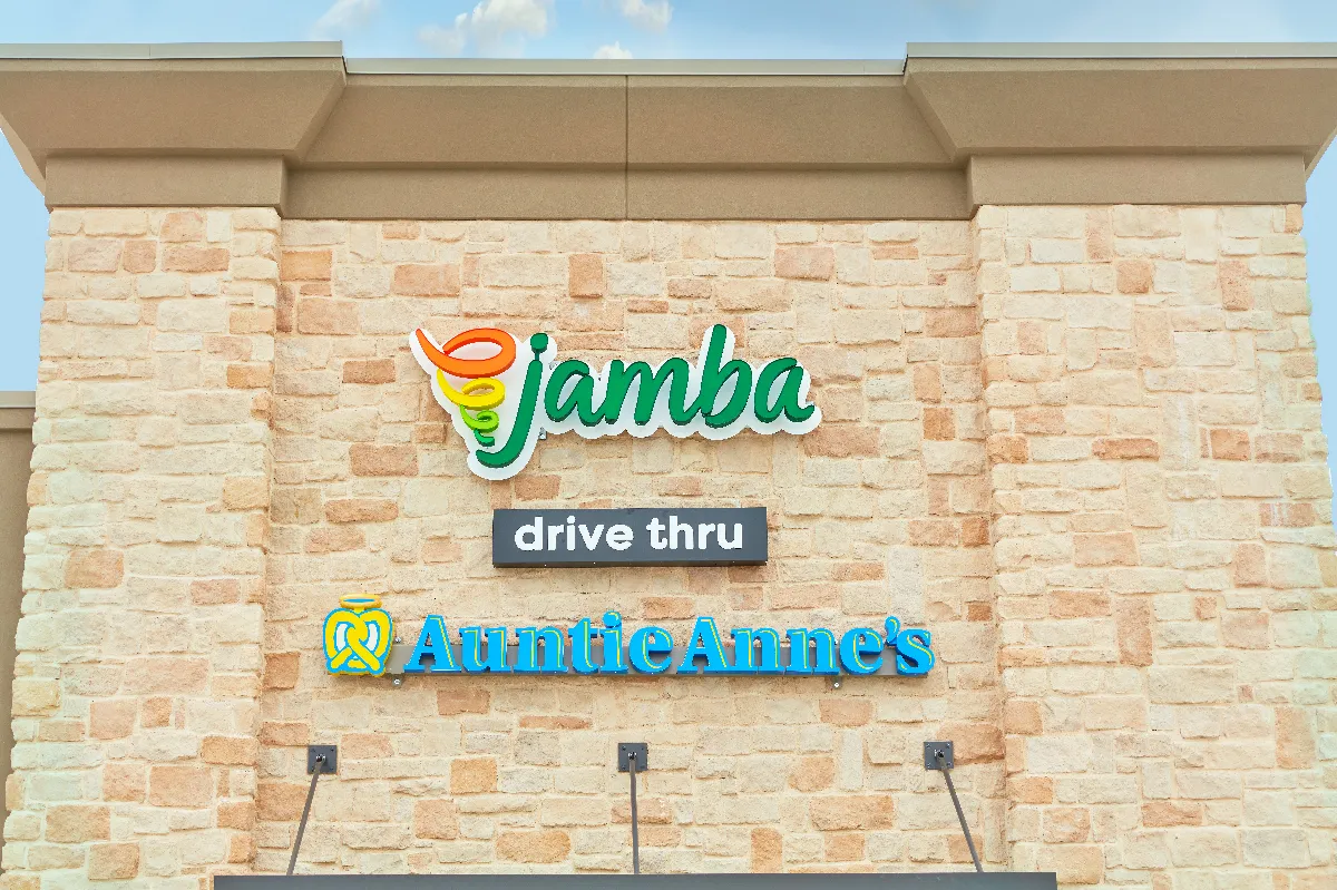 An exterior shot of a beige brick building with the words "Jamba," "drive-thru" and "Auntie Anne's."