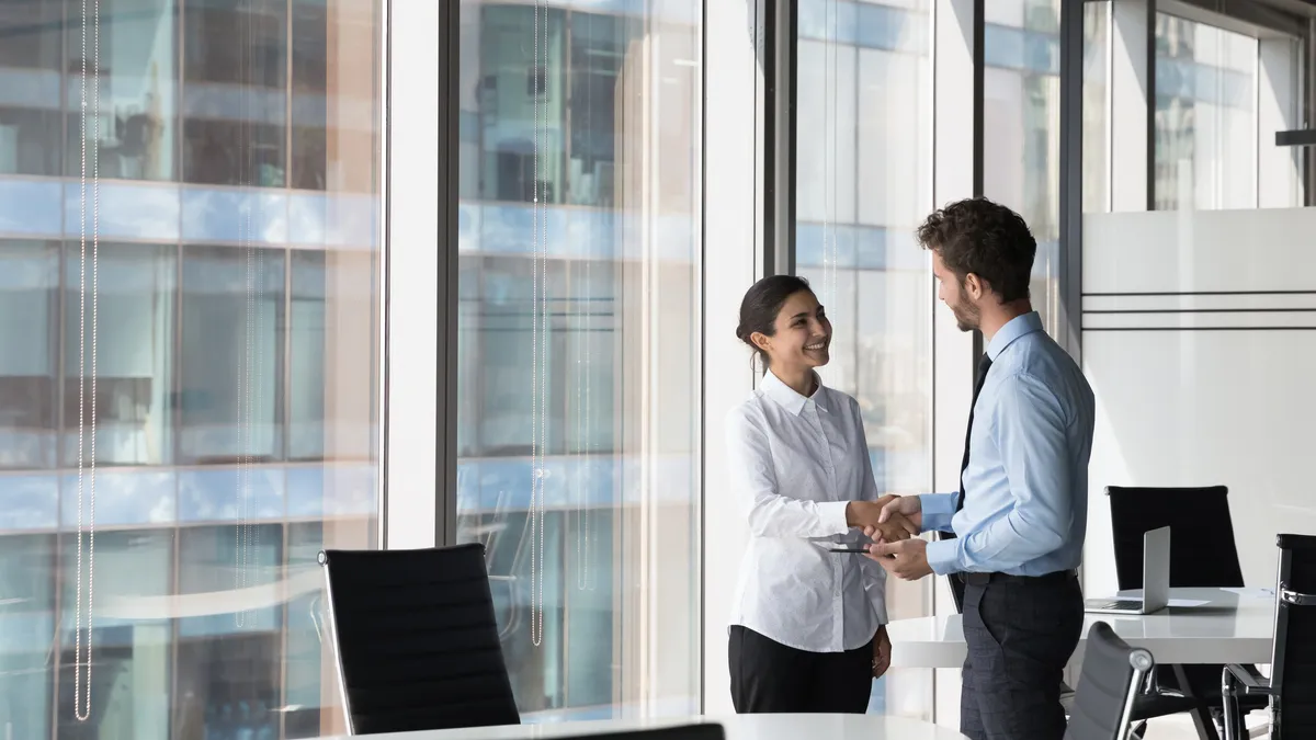 Two people shake hands after a successful job interview.