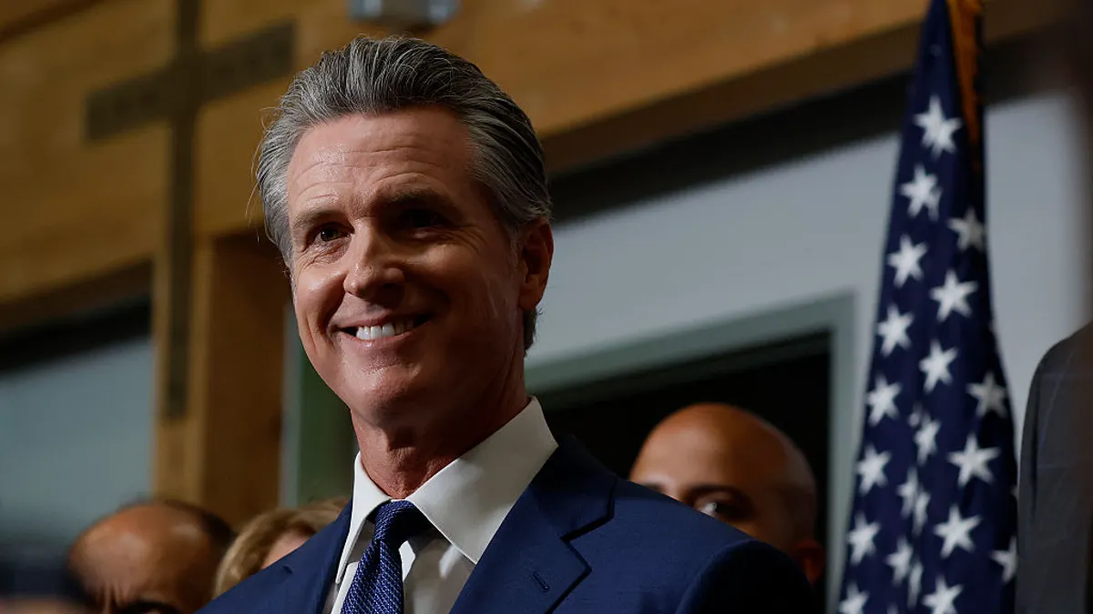 A close-up shot of Gov. Gavin Newsom while he smiles.