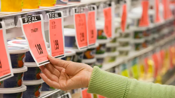 Hand reaching out to "Special" pricing tag in a grocery store.