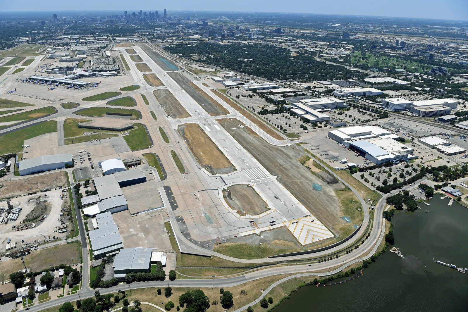 An overhead shot of several runways that loop around and connect to each other. There are bright white markings along the ground, on the pavement.