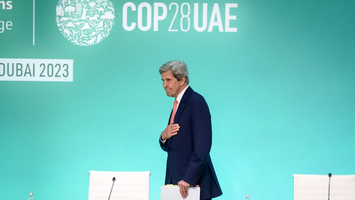 John Kerry stands with his hand below his heart