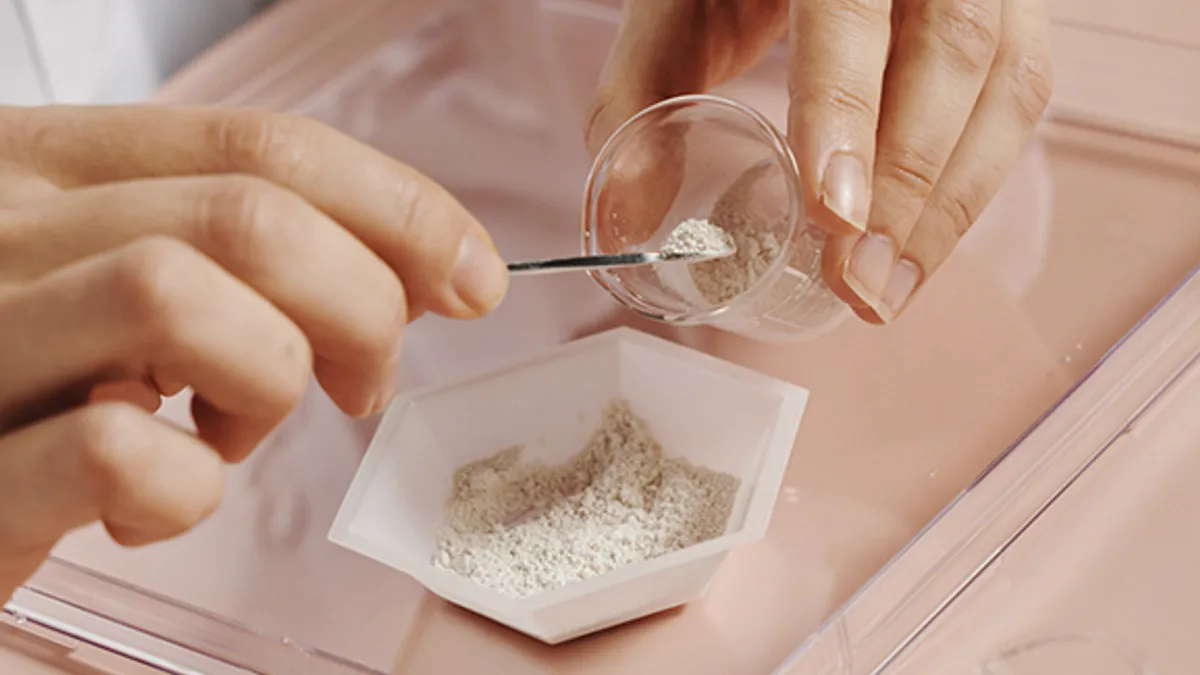 A person is seen holding one of Bolt Threads' materials in a dish.