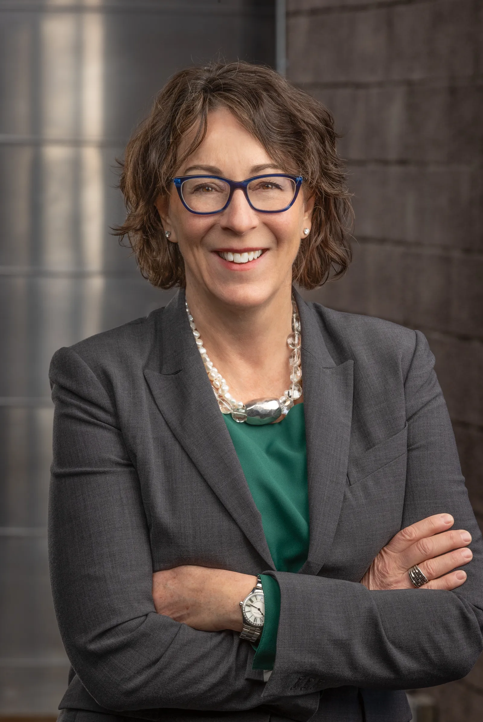 Woman in glasses with gray jacket.