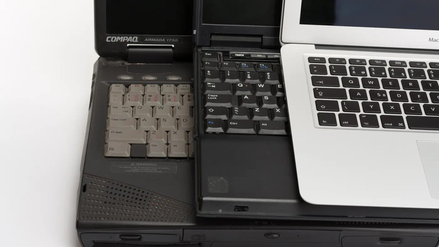Three laptops are stacked atop one another.
