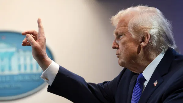 President Donald Trump raises his hand