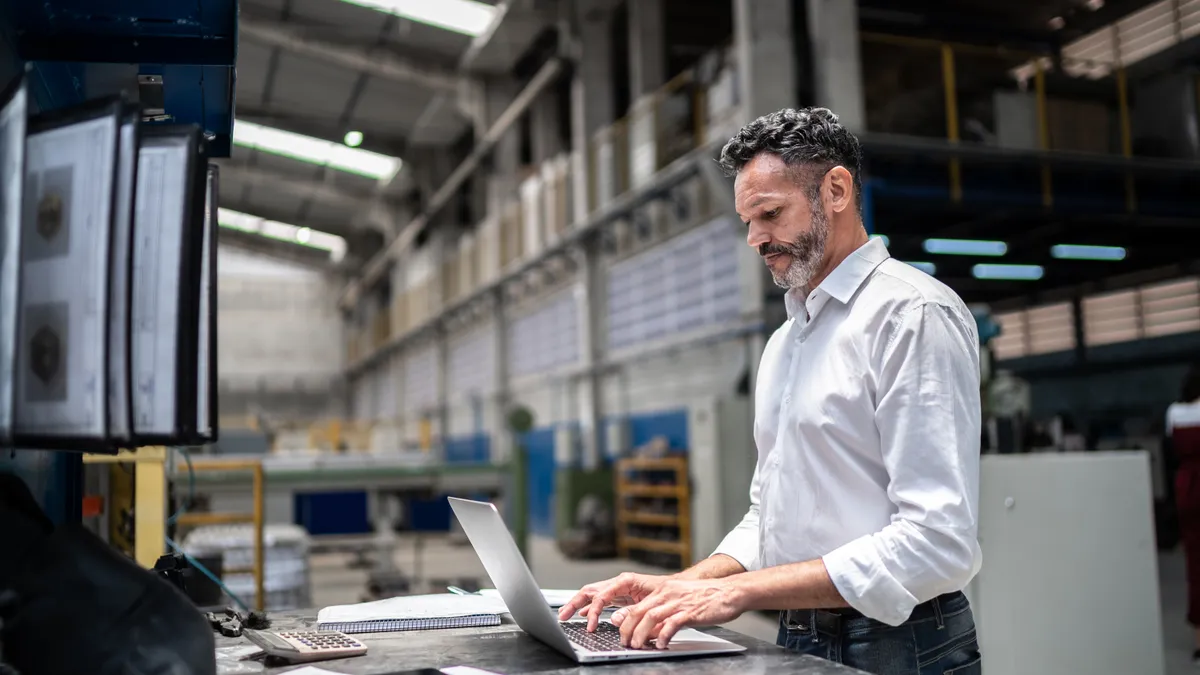 Man using a laptop in a warehouse