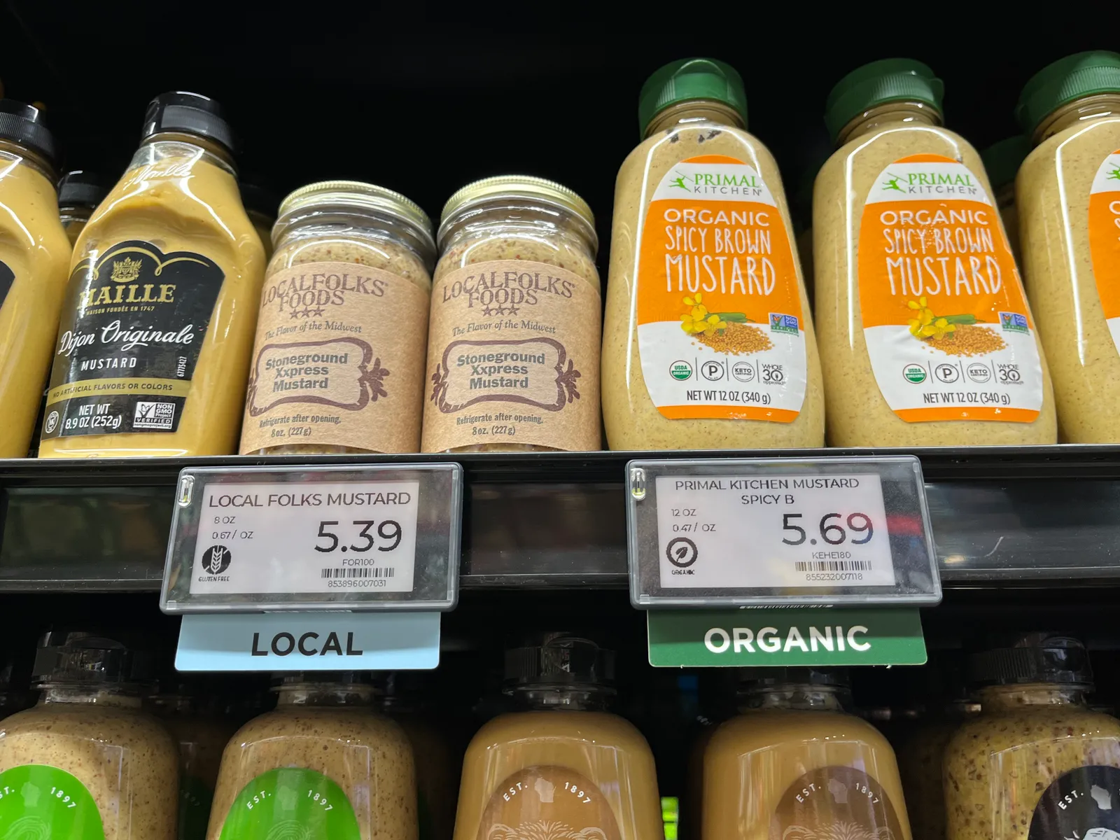 Closeup of grocery store items with "organic" and "local" shelf tags