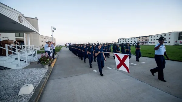 Coast Guard cadets march on a parade ground.