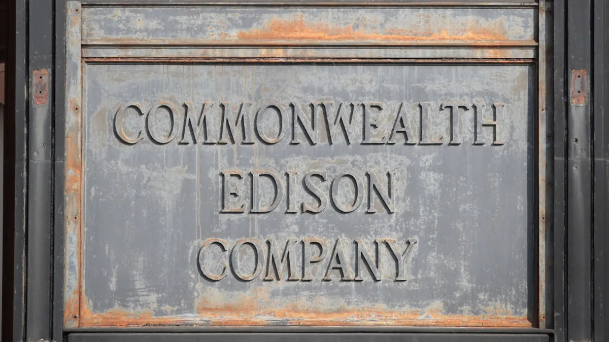 An old, worn, gray stone sign that says "Commonwealth Edison Company" is seen.