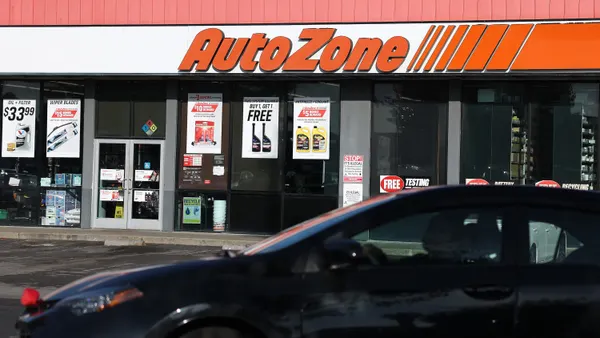 Exterior of an AutoZone retail store, car in foreground