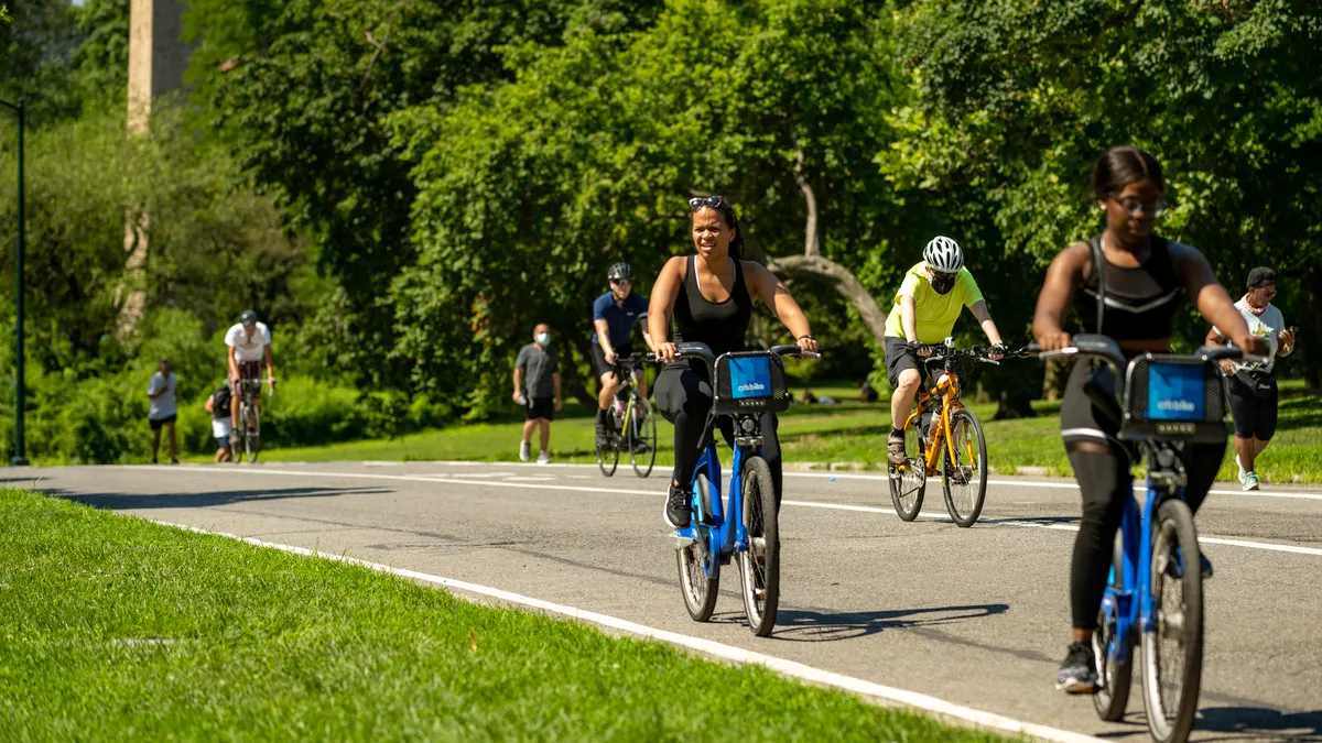 A biker squints in the summer sun as she tops the hill at East 82nd Street on the East Drive in Manhattan's Central Park.