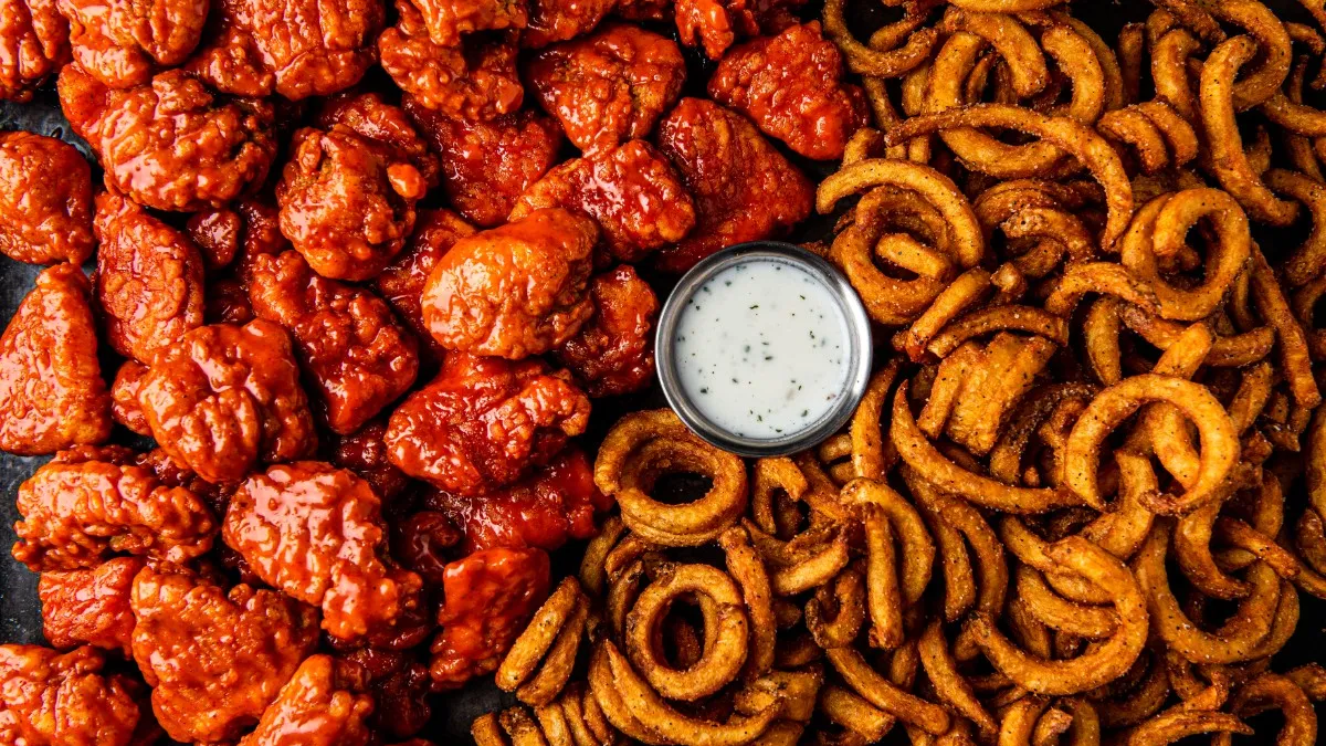 Wings and curly fries offered from Brinker International's It's Just Wings virtual brand