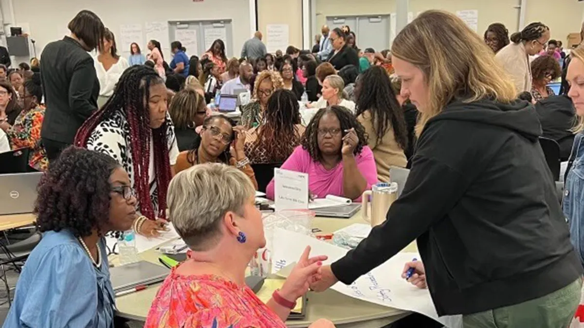 Educators gathered looking at laptops and documents