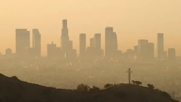 Tall buildings seen at a distance shrouded in smog.