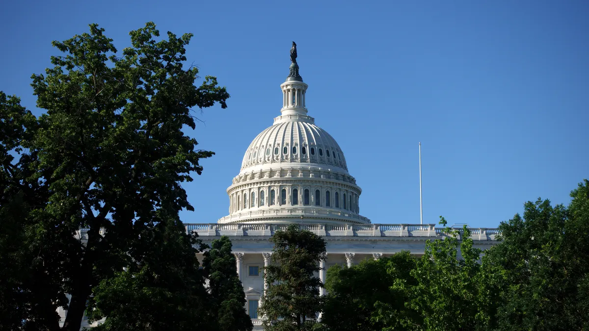 The dome of U.S. Capitol is seen framed by trees.