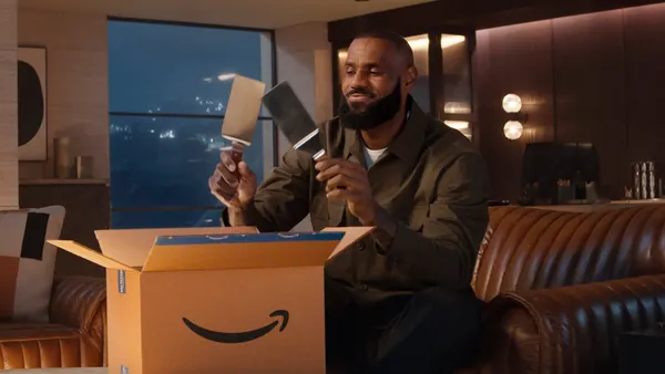 LeBron James holds spatulas that have come out of an Amazon box.