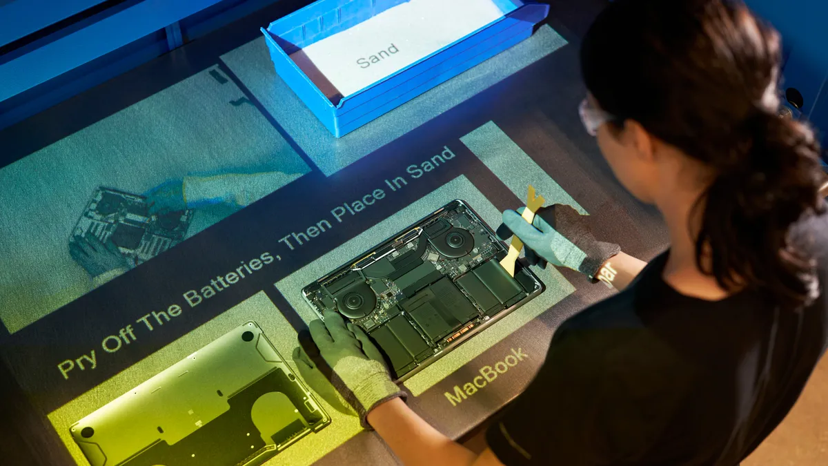 Overhead projector-based augmented reality systems help Apple’s recycling partners disassemble MacBook and iPad models by projecting video imagery directly onto their work surface.