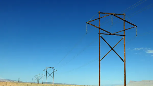 Electric power lines cross a desert.