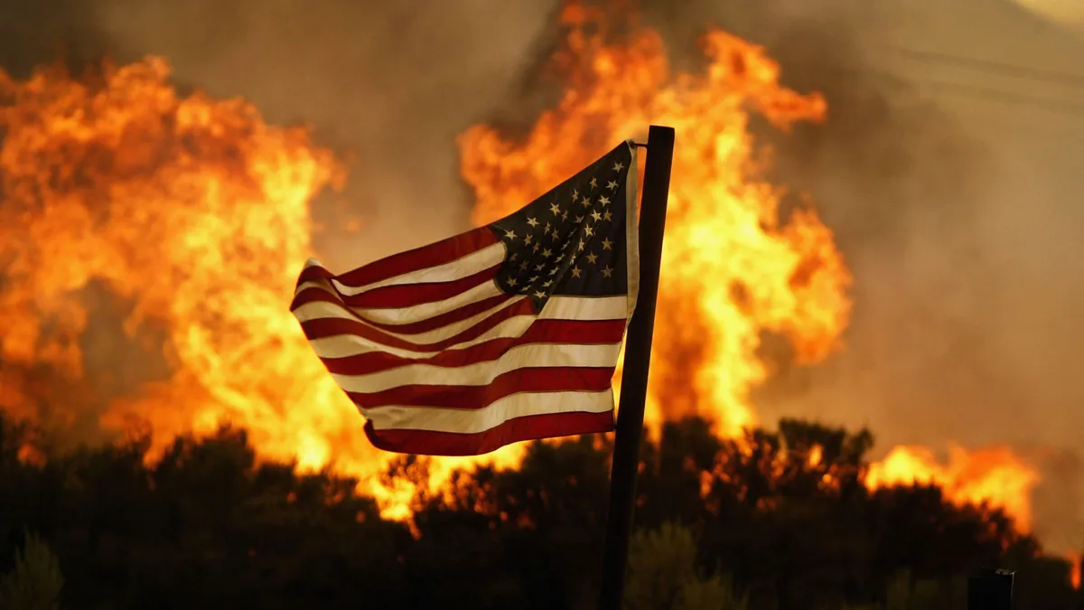 Flames approach an American flag in California.