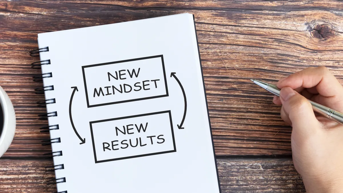 A notebook with written text that says, "New mindset, new results."