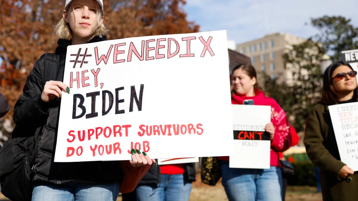 Students hold signs outside the White House in support of new Title IX rules