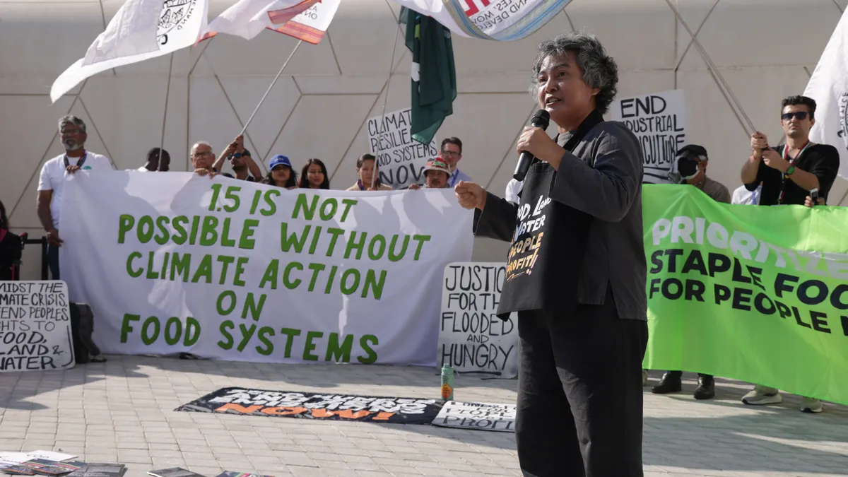 Activists protest with signs calling for climate action on food systems.