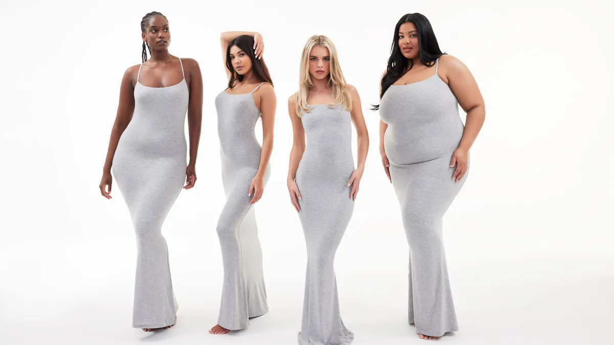 Four people of various body sizes wear white form-fitting floor-length dresses.