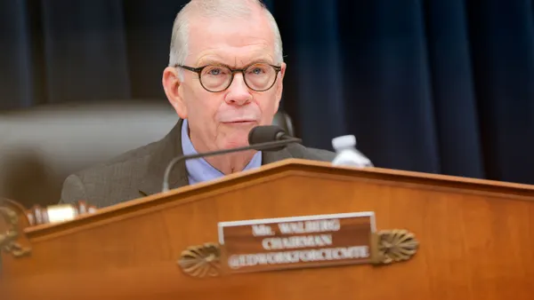 Rep. Tim Walberg sits in front of a microphone while speaking.