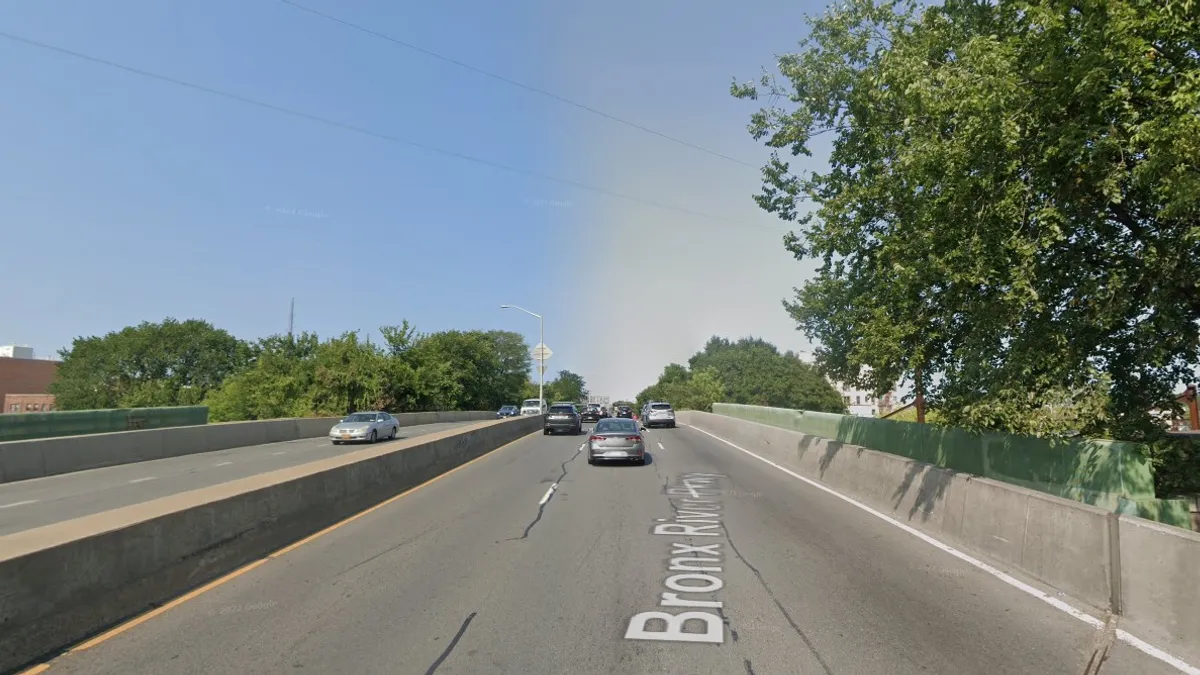 Street view of a simple open concrete bridge.