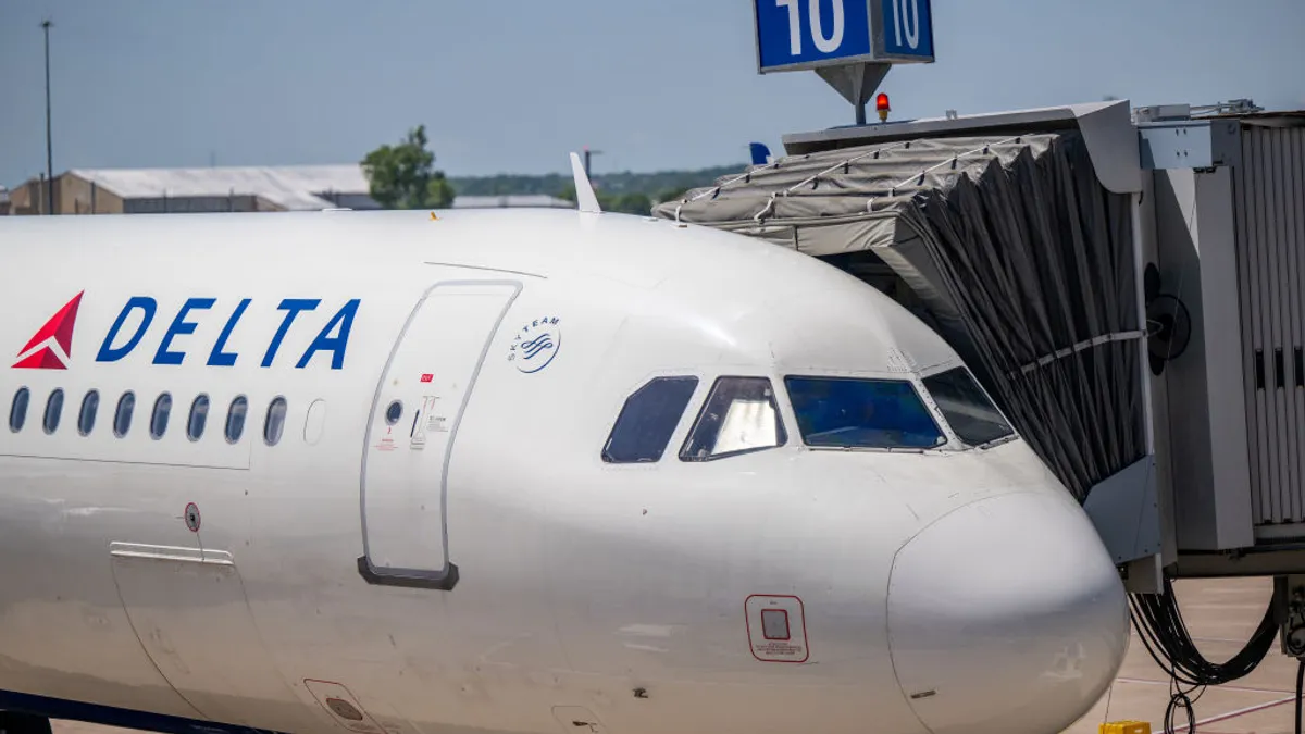 A large airplane marked with the Delta Air Lines logo at an airport terminal