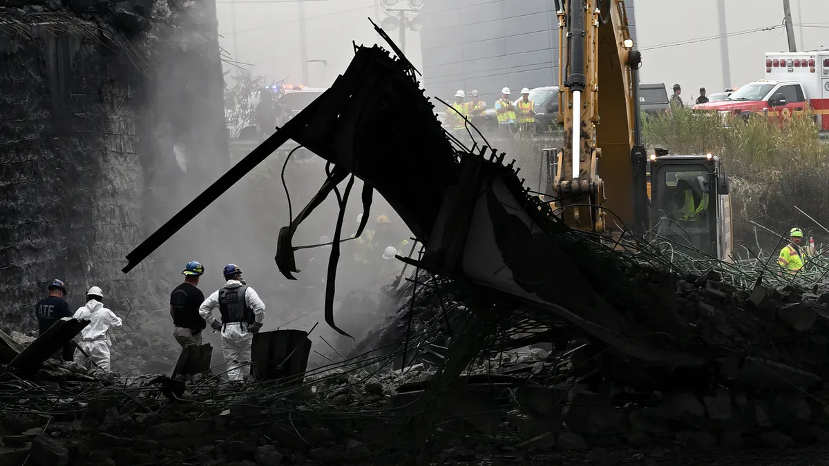 Workers inspect and clear debris from a section of the bridge that collapsed on Interstate 95 after an oil tanker explosion on June 12, 2023 in Philadelphia.