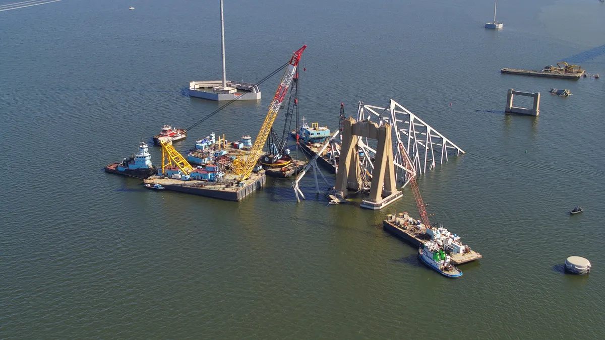 A team prepares to move a large piece of supporting steel from a collapsed bridge.