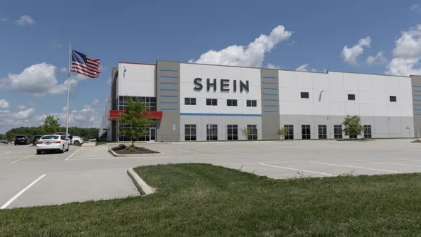 A Shein building is seen across a parking lot, with an American flag to its side.