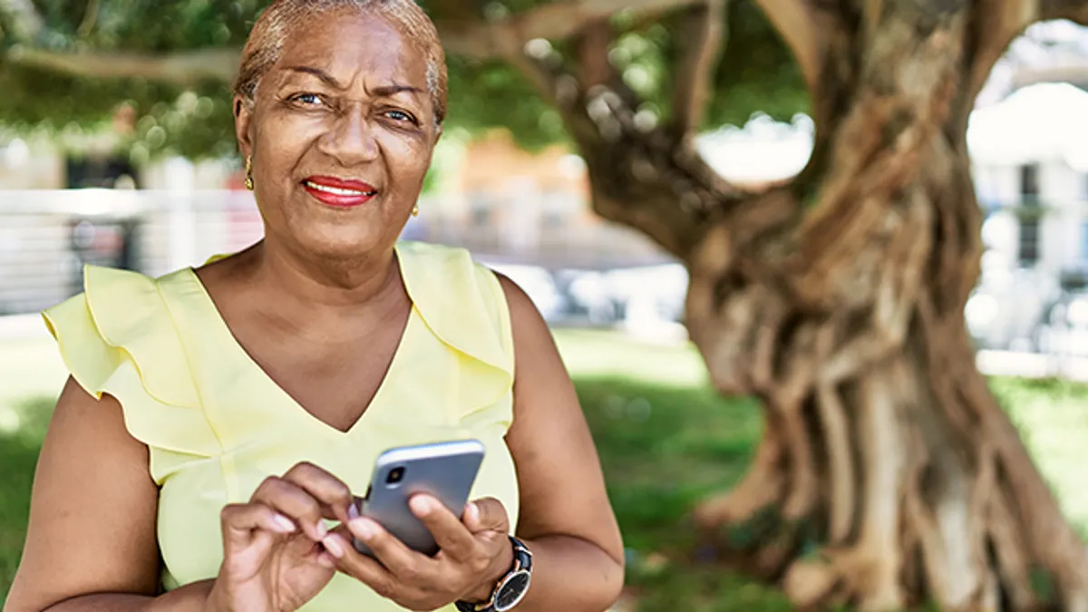 Senior african american woman using smartphone at the park.