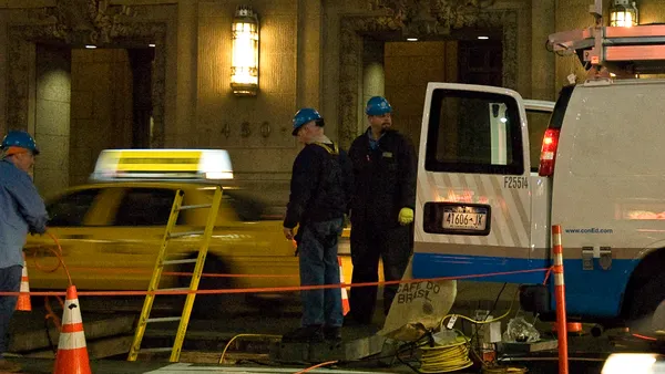 A utility crew stands near a truck.