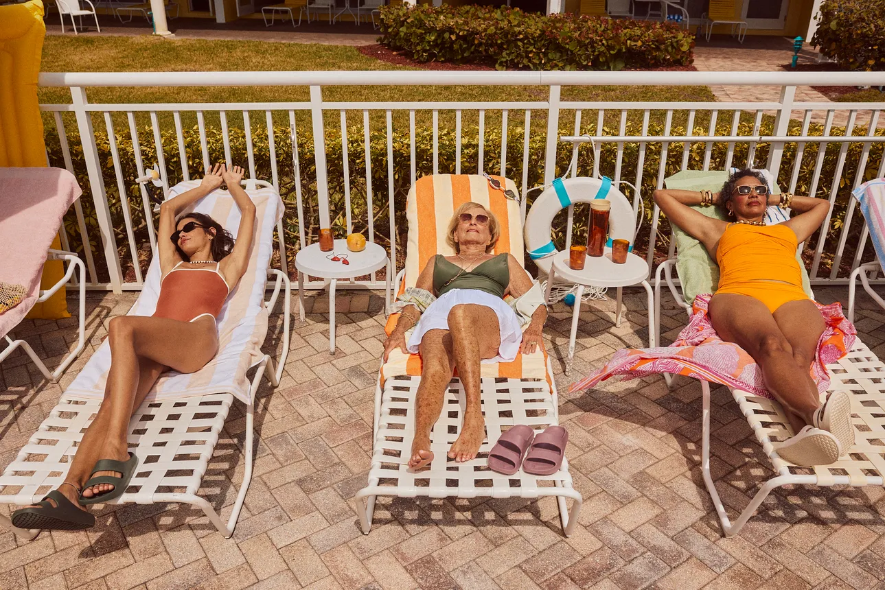 Three people lounging poolside in the Bombas Friday Slide